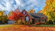 A view of a comfortable brick house with colorful autumn leaves on a bright fall day,Beautiful home in autumn colors with maple trees in the background,residential house in Minneapolis metro area