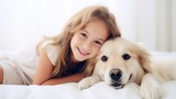 Fototapeta Przestrzenne - Girl and golden retriever creating heartwarming moment on cozy bed. A young girl is lying on a bed with her golden retriever dog. The girl is smiling and looking at the camera.
