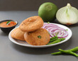 kachori, green chilly and onion slice in plate