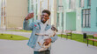 African american man with positive facial expression taking selfie photo with pug dog during walk. Cheerful young male using modern smartphone and having fun with his cute pet on fresh air.