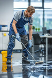 Fototapeta  - A male janitor cleaning the floor in an office