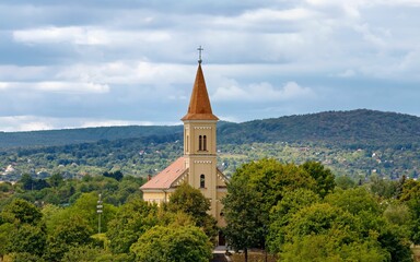 Wall Mural - Countryside landscape with a church steeple visible amongst a line of trees