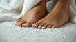 Well-groomed beautiful female feet with white pedicure for pedicure salon. White nail polish. Copy space
