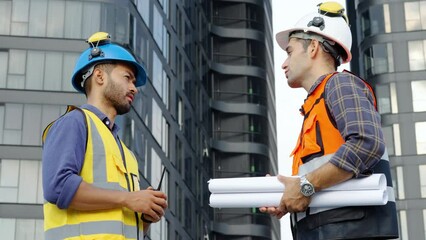 Wall Mural - Contractor, Two civil engineers checking information from blueprint with shaking hands after outdoors meeting, project manager planning and collaboration, urban development in city