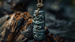 Detailed Maori greenstone pendant on textured burnt wood exemplifying traditional carving