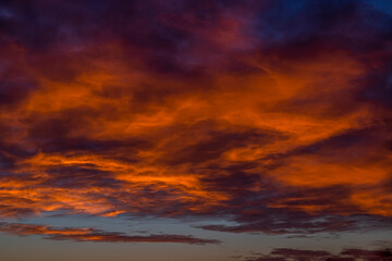 Wall Mural - Beautiful orange clouds in a colorful sky at sunset in summer