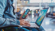 © ramona - Man using a laptop and smartphone for booking hotel online. Sitting in an airport. Tour reservation, Booking online concept.