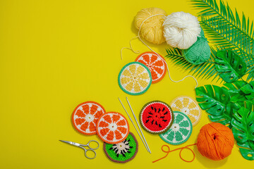 Wall Mural - Handmade summer background. Slices of crocheted fruits, traditional accessory, bright yellow color