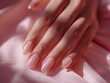 © Vagner Castro - A person's hand with well-groomed nails with semi-permanent pink nail polish under natural daylight. A woman's hand with pink painted nails.