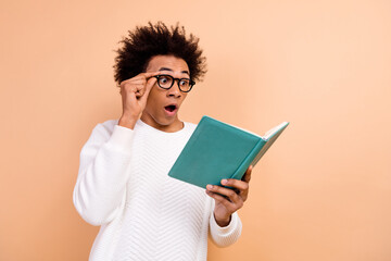 Poster - Photo of excited surprised man wear trendy white clothes look book page open mouth interesting plot isolated on beige color background