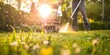 © Anastasiia - Man using a string trimmer to mow grass in a garden with a lawn mower in the background. Concept Gardening, Lawn Maintenance, Power Tools, Outdoor Activities, Landscaping