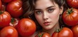   A woman with blue eyes surrounded by a pile of red tomatoes, with one of her faces partially obscured by the tomatoes