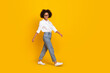 Full length body size view of attractive intellectual cheerful girl going isolated over vibrant yellow color background