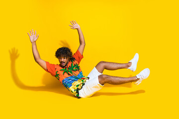 Sticker - Full length photo of funny astonished guy wear hawaii shirt white sneakers hands up falling down isolated on yellow color background