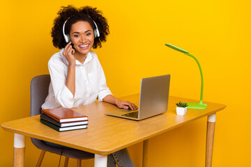 Portrait of attractive trendy cheery friendly skilled girl contact clients distance support isolated over bright yellow color background