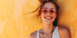Portrait of a young smiling woman on a yellow background on a sunny summer day. Copy space