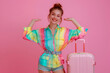 © Gonzalo - Full size photo of attractive girl colorful blouse jump hold suitcase palm hold offer look empty space isolated on pink color background
