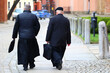 Ksiądz katolicki w czarnej sutannie idzie na mszę świętą