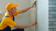 © DenisProduction.com - Engineer draws scheme on the wall. Builder making measurements on a white wall.