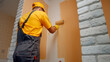 © DenisProduction.com - Worker paints the wall roller. House painter paints the wall in brown.