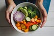 Hand of woman holding salad bowl with fresh vegetables - healthy eating concept