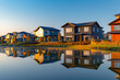 A crisp morning view of modern houses reflecting early sunlight in a landscaped neighborhood. /