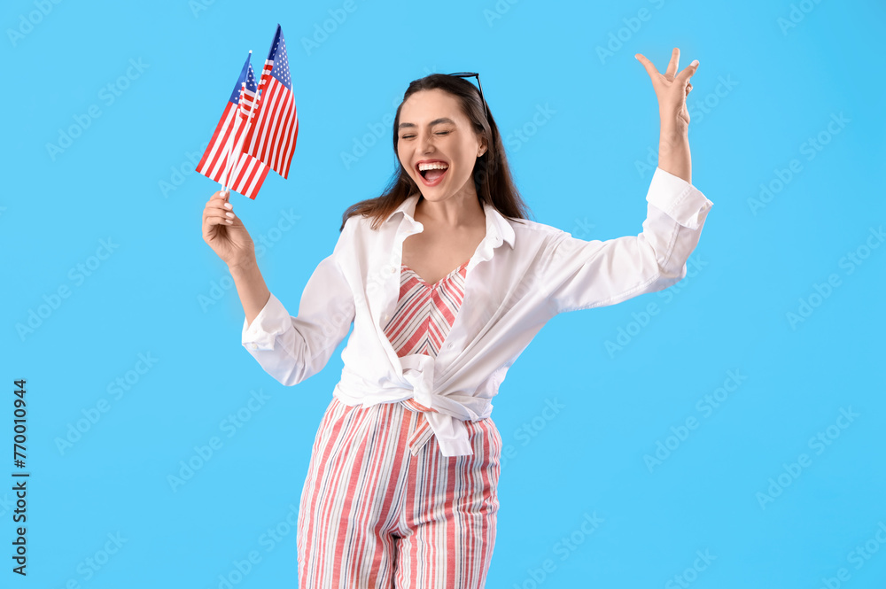 Happy young woman with USA flags on blue background