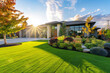A state-of-the-art custom residence features a neat, green front lawn and modern landscaping in the late afternoon sun.
