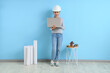 © Pixel-Shot - Little architect using laptop near blue wall