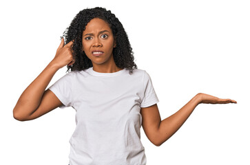 Wall Mural - African American woman in studio setting holding and showing a product on hand.