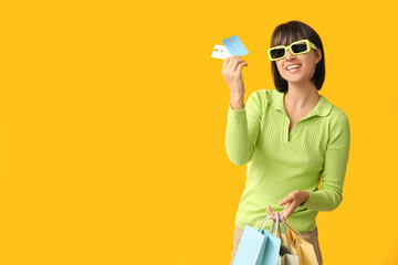 Sticker - Beautiful young woman with credit cards and shopping bags on yellow background