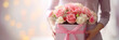 Close up of gift box with pink bouquet on gift box in female hands. Banner or gift card for Happy Mother's Day or Happy Women's day, birthday.