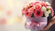 Close up of box with pink bouquet on gift box in female hands. Banner or gift card for Happy Mother's Day or Happy Women's day, birthday.