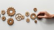 Flat lay of interconnected wooden gears arranged on white background, illustrating teamwork, strategy, and business processes.