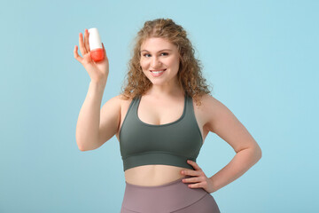 Poster - Beautiful young woman with deodorant on blue background