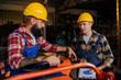 © Zamrznuti tonovi - Colleagues in a workshop working on the agricultural machinery problem