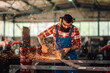 © Zamrznuti tonovi - Bearded worker in work overalls and protective goggle grinding a metal