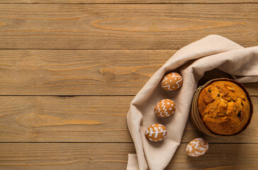 Wall Mural - Easter cake and painted eggs on wooden background. Top view