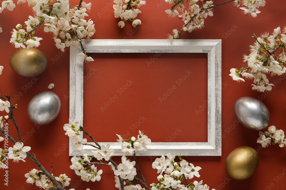 Frame with Easter eggs and blossoming branches on brown background