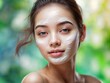 
A charming, young girl of oriental appearance with a mask applied to her face. Facial skin care.