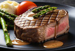 close up of medium rare steak on black dish