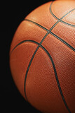 Fototapeta Sport - Basketball ball on a black background close-up blur, sports background