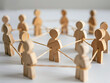 a group of wooden figures standing and connected each other with a line, networking collaboration or communication, teamwork, organization image concept.