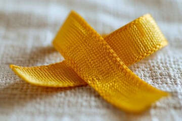 A yellow ribbon is laying on a white surface
