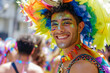 Man at gay pride parade, smiling homosexual man filled with colorful feathers in streets filled with lgbt people