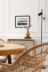 Poster - Tasty croissants on table and wicker chairs in dining room. Interior design