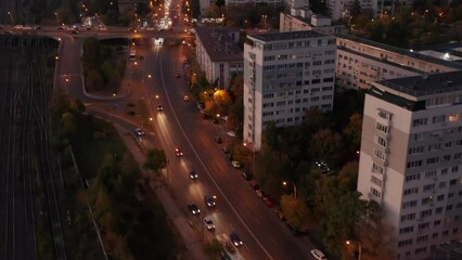 Wall Mural - Bustling Bucharest traffic at sunset transitioning into night, city lights aglow