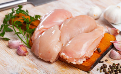 Wall Mural - Raw chicken breast fillet ready for cooking on wooden table