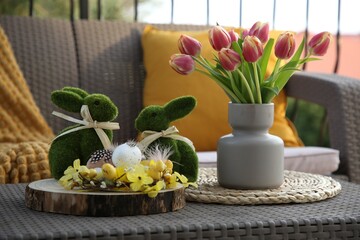 Sticker - Terrace with Easter decorations. Bouquet of tulips in vase, bunny figures, decorative nest and eggs on table outdoors