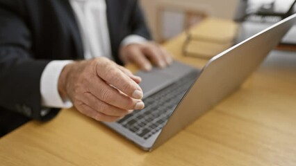 Canvas Print - Unseen hands of resilient senior man, a working warrior executing business tasks on laptop, indomitably dominating the office space